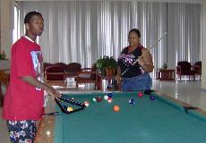 Terrell Scott, freshman from Kilgore, Texas,  and Candice Abney, freshman from New Orleans, play pool in the now co-ed Ellender dorm lobby.