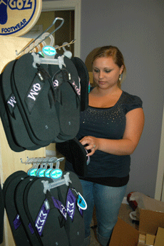 Emily Bonvillain sorts through personalized flip-flops, some of the many items that will be for sale in her new store. 