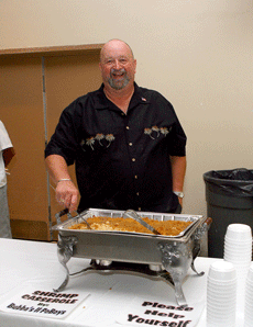 The late Norm Swanner, co-founder of Sponsor A+ Scholar, serves food at the Bubbas II food station at this years event Oct. 18 in the Cotillion Ballroom.