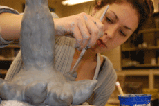 Erin Chauvin glazes a clay sculpture in the ceramics lab in Talbot Hall Monday.