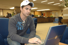 Kelsi Guidry, health and wellness senior from Cut Off, checks his Web site in Ellender Memorial Library. Guidry operates three Web sites from his home.