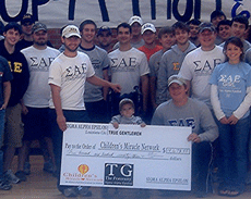 Sigma Alpha Epsilon Nicholls Chapter and a child representative of the Childrens Miracle Network poses with a check SAE donated to the organization. SAE held a Stay-Up-A-Thon in Stopher Gym Nov. 30 to help raise money for the charity.