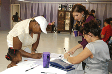 Roshawn Harris from Thibodaux registers her daughter Jazlyn Harris for dance classes at To The Pointe Sunday with the help of co-owner Nikki Baye, general studies senior from Thibodaux, and her mother Lynne Baye.   