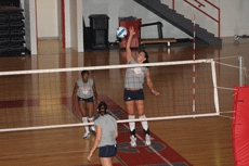 Sophomore middle hitter Amy Beshir jumps for a spike Aug. 16 in Sopher Gym with the support of junior Enjoll Ford and other Lady Colonels.