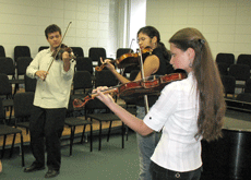Christiano Rodrigues, freshman from Joao Pessoa, Brazil; Raquel Coutinho, freshman from Joao Pessoa, Brazil and Hannah-Phyllis Urdea-Marcus, freshman from Bucharest, Romania, play their violins during practice.
