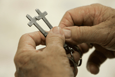 Jim McNeill, a re-entry specialist, holds two cross key chains to be given to inmates being released from the Carol Vance Unit Oct. 3 in Richmond, Texas. Inmates at the prison are in the InnerChange Freedom Initiative program.