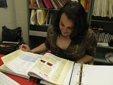 Joelle Bonamy, assistant professor for languages and literature, browses a Spanish language textbook before class in her office.