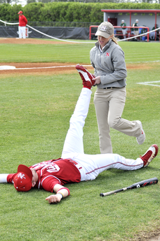 Nicholls trainer Amelia Mason stretches out junior outfielder Chris Murrill before a game at Ray Didier Field. March is Athletic Training Month.