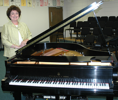 Carol Britt, director of the School of Fine Arts, stands by one of the Steinway pianos the University was able to purchase through funds raised at last years Monster Piano Concert. This years concert is scheduled for Sept. 22.