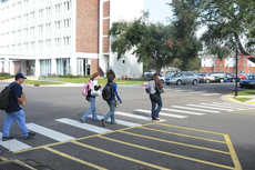 Students use the crosswalk at the corner of Afton and Acadia drives on Wednesday on their way to class.