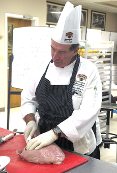 George Kaslow, assistant professor for the John Folse Culinary Institute, prepares a cut of veal during his Meat Identification and Fabrication class Tuesday in Gouaux Hall.