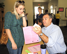 Director of Campus Recreation Michael Matherne explains the procedure for receiving the H1N1 vaccine to Misty McMillian, pre-medicine senior from Houma, Wednesday at the La Maison du Bayou Clubhouse.