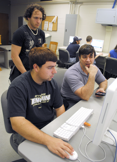 Kent White, associate professor of computer science, assists Nick Bilello, computer science senior from Thibodaux, and Joshua Falgout, computer science junior from Houma, during their iPhone Development class Tuesday in Peltier Hall.  Students in the clas