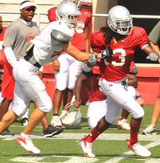 Freshman wide receiver Mike Barba tries to tackle senior defensive back Dominique Daniels (13) during practice Aug. 15 at John L. Guidry Stadium.