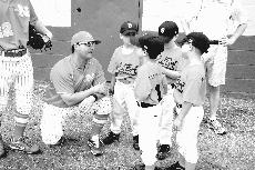Coach Seth Thibodeaux talks to a group of baseball players before a game in the 2010 season.