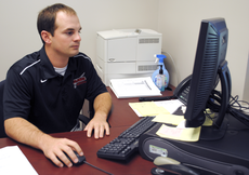Brandon Ruttley, associate director of marketing and development for athletics, works in his office Tuesday in Candies Hall.