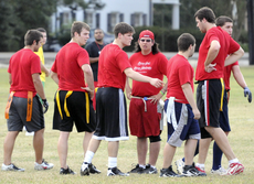 Members of the Baptist Collegiate Ministry discuss strategy during their flag football game Tuesday at the St. Thomas Aquinas field.