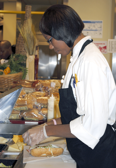 Vernon F. Galliano Hall employee Tanika Carter works at the cafeteria deli on Monday.