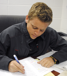 Brandon Rizzuto, director of media relations, copy edits press releases in his offi ce on Wednesday.