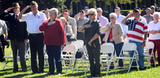 Attendees of last year's Veteran's Day program salute the flag at the end of the ceremony.