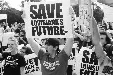 Gavin Chauvin, junior biology major from Houma, holds up a sign and chants at the Save Higher Education protest at the state capitol on Nov. 10.