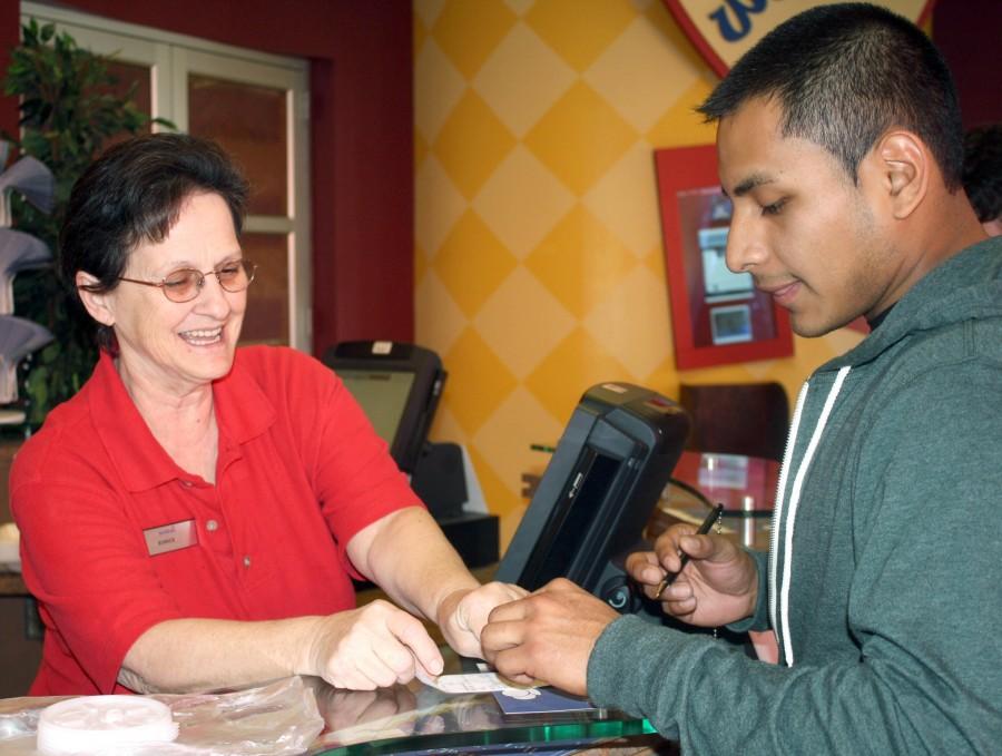 Ms. Eunice hands a student his receipt on Monday in the Galliano Dining Hall. Ms. Eunice said she loves working at Nicholls and doesn’t believe in bad days.