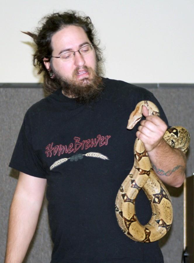 Leith Adams, instructor of biological sciences, holds his red-tailed boa, Jörmungand, during his Biology 106 class on Monday in Gouaux Hall.