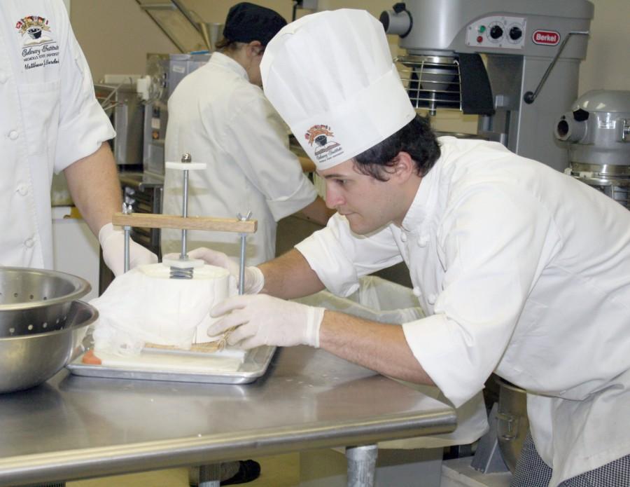 Nicholas Hymel, culinary arts senior from Raceland, makes sure the cheese mold is level during his cheese-making class on Monday in Gouaux Hall.