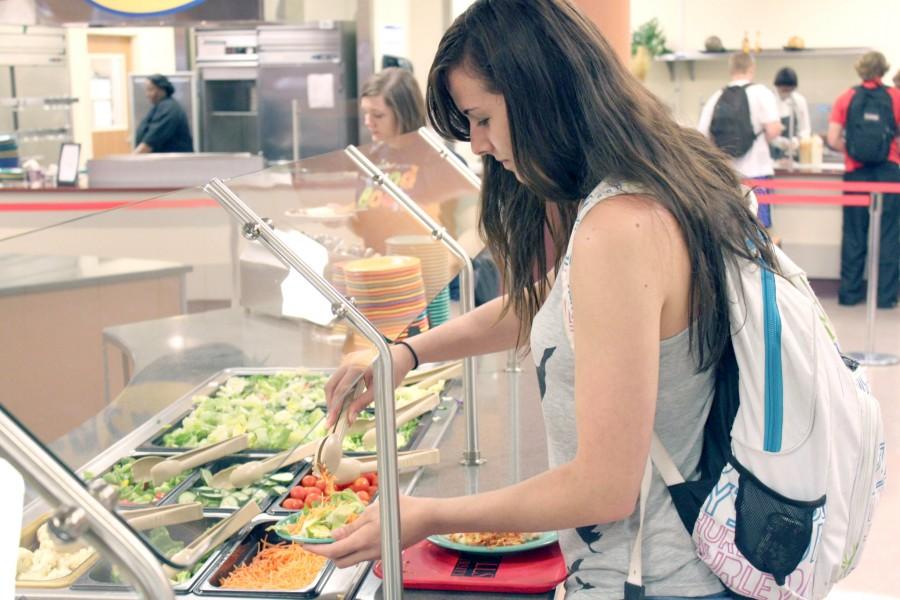 Jessica Gast, freshman from Houma, makes a salad on Monday at the salad bar in Vernon F. Galliano Hall Cafeteria.