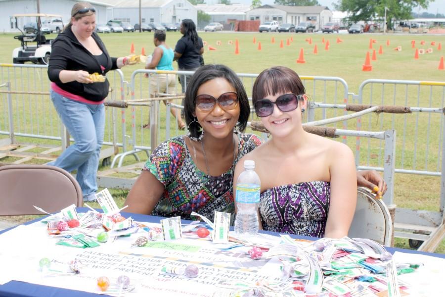 Brittany White, public relations senior from Houma, and Kacey Alario, public relations and print journalism senior from Galliano, work the table for “It’s a hard txt=ripat Crawfi sh Day last Thursday.
