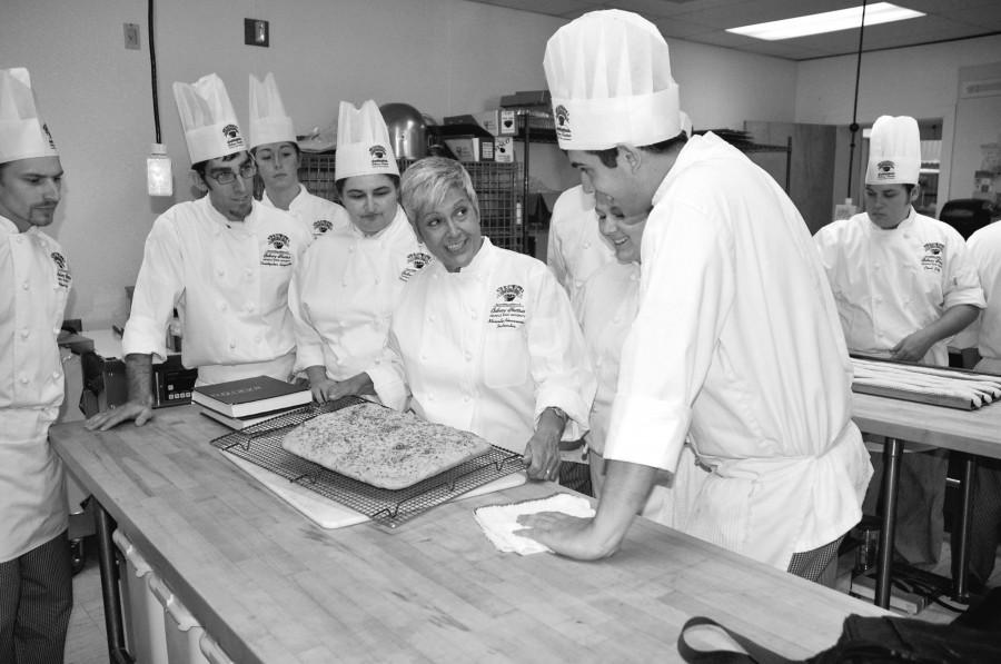 Chef Marcelle Bienvenu, instructor for the John Folse Culinary Institute, discusses a dish with Greg Doucet, culinary junior from Lafayette, as classmates observe during a baking class on Tuesday, Aug. 30.