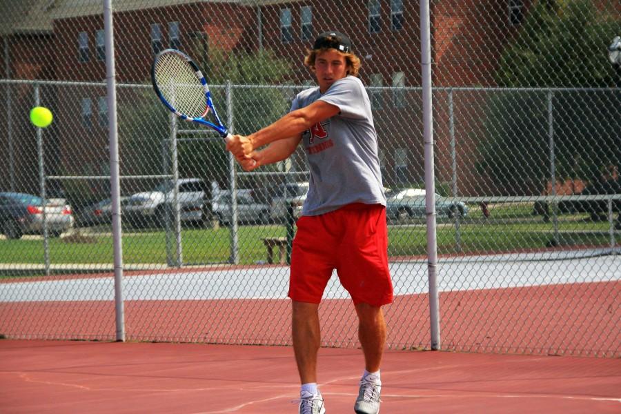 Dmitry Kozionov, junior from Izhevsk, Russia, warms up by smashing a backhand to his teammate during practice on Friday at the Nicholls tennis courts.