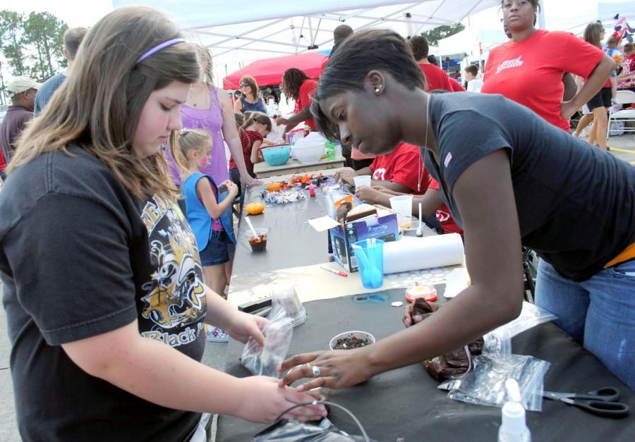 Bianca Brown, culinary arts and elementary education sophomore from Shreveport, helps Julie Vedros, 12, from Houma make a “dirt cup” dessert at the NAACP booth during Family Day on Oct. 23, 2010.