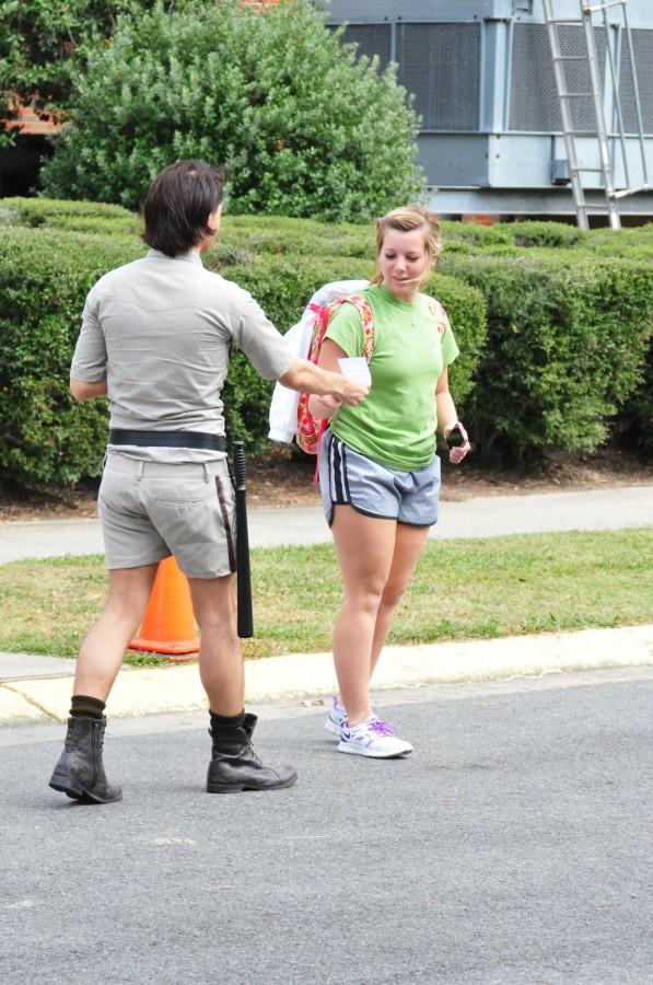 Dressed as a crosswalk policeman, Dalton Primeaux, mass communication senior from Raceland, hands out a violation notice to Abby Bourgeois, freshman from Thibodaux, for Crosswalk Awareness Month on Tuesday. 