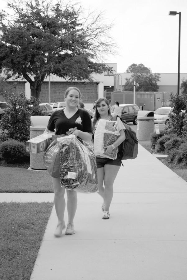 Brittany Whatley, English junior from Houma, and Michelle Prejant, nursing junior from Labadieville, help students move into Scholars Hall on Saturday.