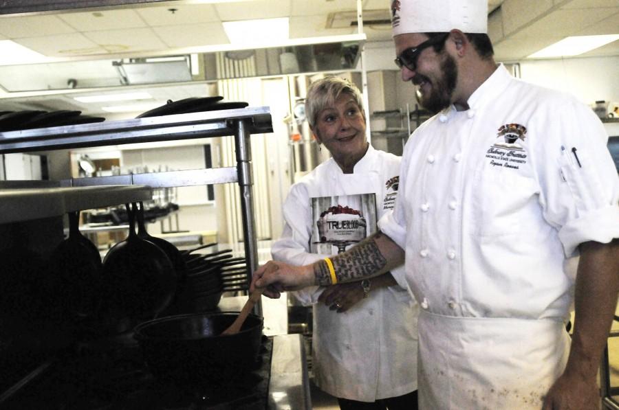 Chef Marcelle Bienvenu guides senior culinary major, Ryan Reeves, as he practices his cooking skills.