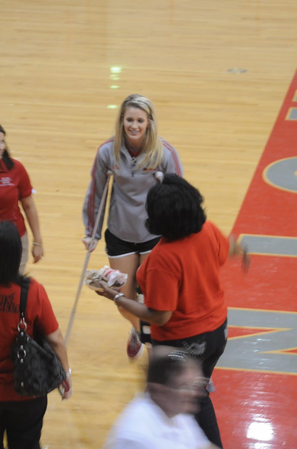 Injured Brooke Hopper, junior from Tomball, Texas, walks around the court to meet with her team during half time.