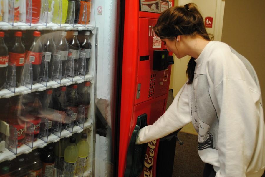 Caroline Callais, general studies freshman from Larose, gets a water from the vending machine in Scholars Hall Tuesday evening