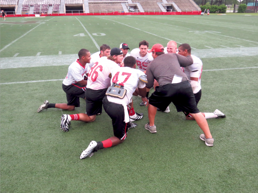 Tight End Coach Brandon Nowlin huddles with his players at practice.