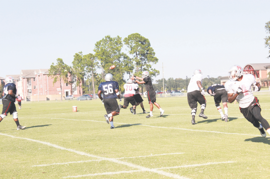 Quarterback Tuskani Figaro, #8, a sophomore from Lafayette, La, passes the ball to a teammate during practice.