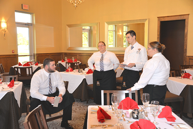 Christopher Adkins addresses the other waiters on duty for the Bistro Ruth hosted by the culinary arts majors at the Larry D. Ledet Culinary Arts building on Tuesday afternoon.