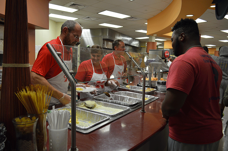 Claude Verdin waits in line to be served by faculty during the homecoming breakfast in the Galliano Dining Hall on Monday night.