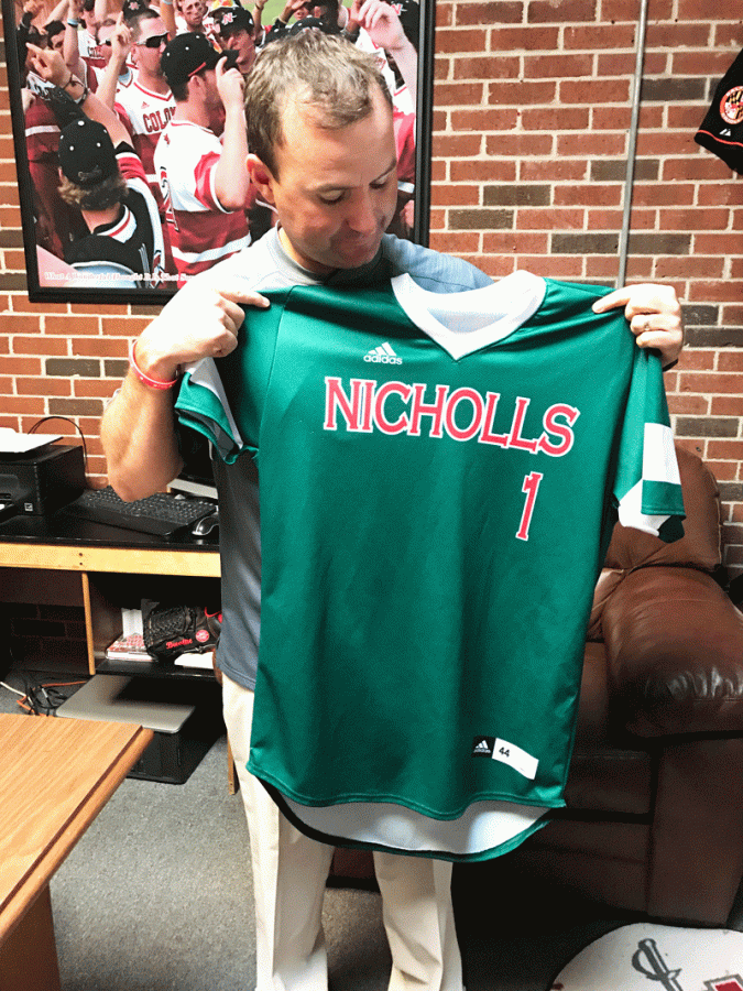 Coach Seth Thibodeaux shows off the jerseys that will be auctioned off for the Louis Children Crisis Center tomorrow night at Ray. E. DIdier field.