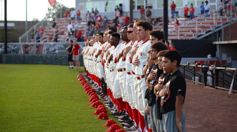 Nicholls baseball team joined by a local youth baseball team, the Huskies, pauses for the national anthem against Southern University March 22.