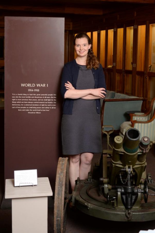 Helen Thomas, assitant archivist, stands next to World War I exhibit in Ellender Memorial Library.