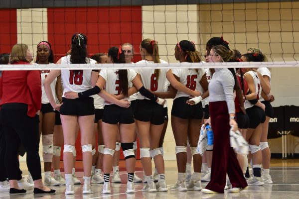 The Nicholls women's volleyball team huddling before taking the court