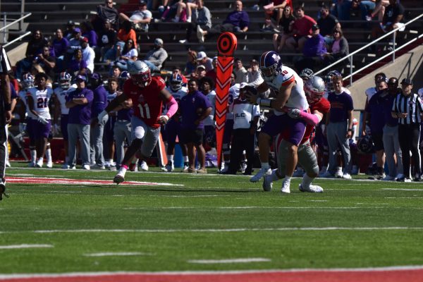 Nicholls linebacker Jake Delmado[behind quaterback] sacks Northwestern State University's quarterback[#10}