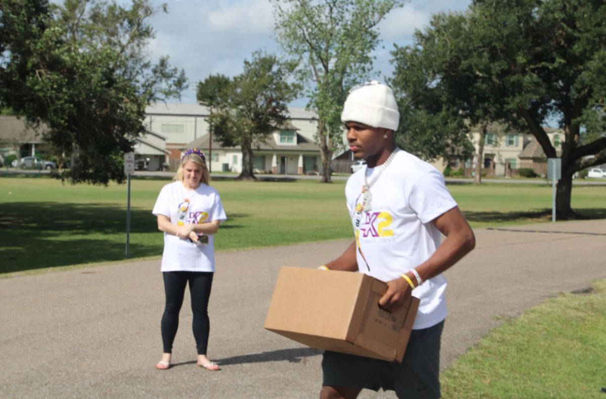 LSU receiver Kyren Lacy carries a box with donated food for his Thanksgiving turkey drive (11/2/2024)