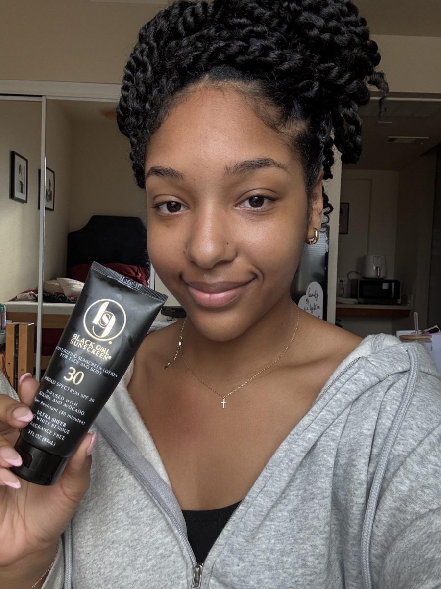 Mikaylah holding a tube of Black Girl Sunscreen, one of her favorite Black Owned beauty products