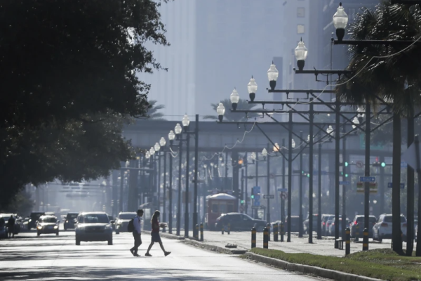 Pedestrians cross Canal Street in New Orleans. (Photo by: David Grunfeld/The Times-Picayune/The New Orleans Advocate via AP)
